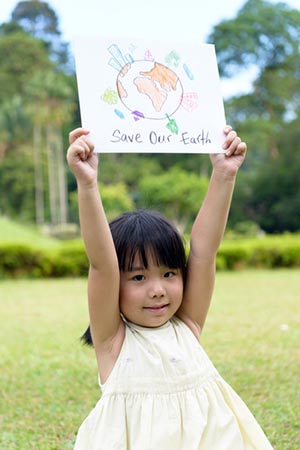 Young girl holding up sign to save our planet